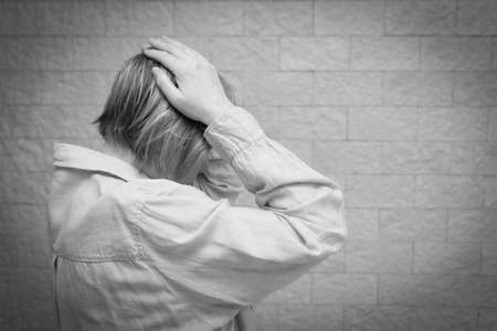 Senior woman addict and alcoholism alone depression stress sitting on the floor with her head in her...