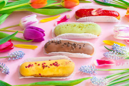 Delightful eclairs and vibrant tulips and muscari flowers. Still life Hello summer mood. Concept...