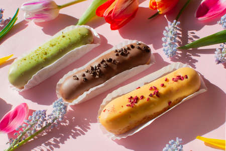 Delightful eclairs and vibrant tulips and muscari flowers. Still life Hello summer mood. Concept...