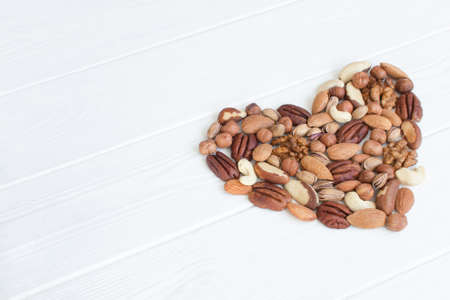 Organic mixed nuts. Assorted heart nuts: hazelnuts, walnuts, Brazilian nuts, pecans, pistachio,...