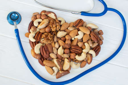 Organic nuts in the shape of a heart and a stethoscope. Healthy food for the heart, useful...
