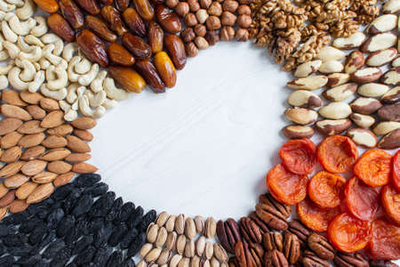 Assorted nuts banner from the center: dates, hazelnuts, walnuts, Brazilian, dried apricots, pecans,...