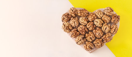 Organic nuts banner background are shaped like a heart. On a minimal background. Healthy food for the heart, useful microelements and vitamins. Useful snack for vegetarians and more. Healthy Concept.の写真素材