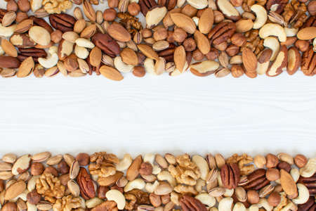 Organic mixed nuts banner with place for text. Assorted nuts: hazelnuts walnuts, brazilian nuts, pecans, pistachio, almonds, cashews. Healthy food, useful microelements and vitamins. Healthy Conceptの写真素材