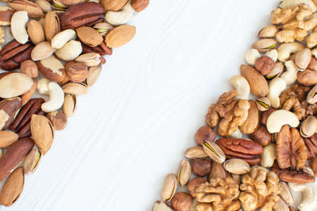 Organic mixed nuts banner with place for text. Assorted nuts: hazelnuts walnuts, brazilian nuts, pecans, pistachio, almonds, cashews. Healthy food, useful microelements and vitamins. Healthy Concept.の写真素材