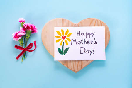 Mother day card, heart wood, bouquet carnation. Text Happy Mothers day. On a colored background....