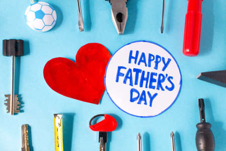 Happy father day flat lay. Blue background with tools, give dad a present and a heart with the...