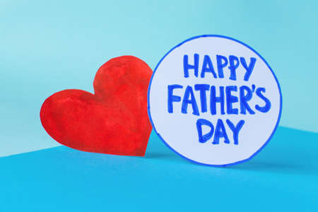 Happy Fathers Day flat lay. Blue minimal background heart with the inscription: Happy Fathers Day....