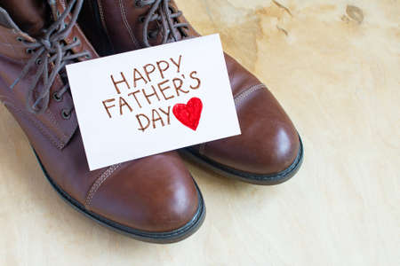 Fathers Day celebration. Big shoes on a wooden background. Father day composition
