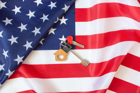Keys to a new home and the Flag of America. Immigration and relocation to the USA. Memory Day concept. Federal holiday in the United Statesの写真素材