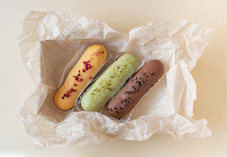Eclairs on a craft paper background. Still life hello dessert mood. Traditional French dessert with...