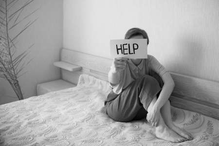 Women with text help. Woman violence and abused concept. Health care concept, stress, headache, migraine psychological health, emotional anxiety. Social documentary concepts black and whiteの写真素材