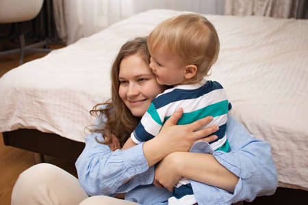 Happy baby. Little caucasian white baby with mom in the bedroom. Family life, moms love, motherhood