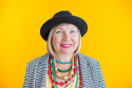 Happy senior woman having fun in stylish clothes, concepts about senior people on colored...