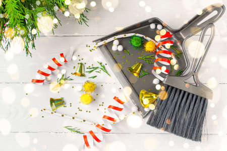 Christmas cleaning after. Cleaning tools broom and scoop and broken Christmas decorations after party top view flat lay on white background. Concept of cleaning after holiday, clean up the mess.の写真素材