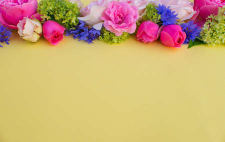 Composition of beautiful flowers, on yellow background. Flowers spring or summer frame. Colorful...
