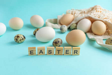 Easter eggs with natural decor. Zero Waste Easter Concept. Natural rustic eggs in a string bag on a blue background.の写真素材