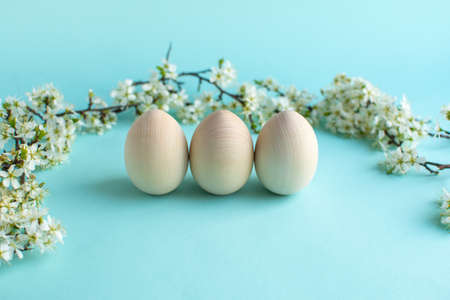 Happy Easter zero waste concept. Easter wood eggs with natural decor and fresh flowers. Christian...
