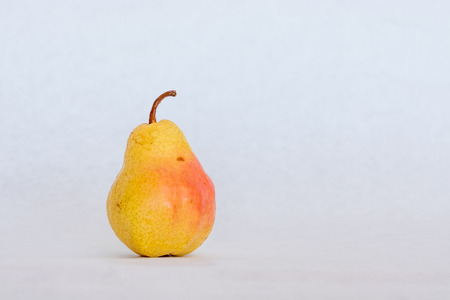 One ripe yellow skin pear slightly imperfect fresh organic beautiful studio shot Bartlett with stemの写真素材