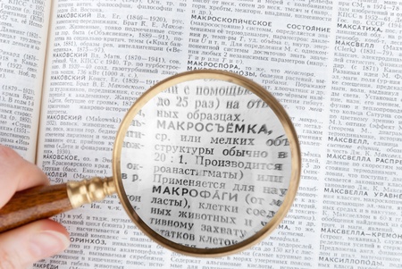 Magnifying glass enlarging text in big bookの写真素材
