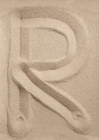 Letter R of the alphabet writing on the sandの写真素材