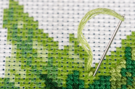 Cross stitching with a needle very closeup