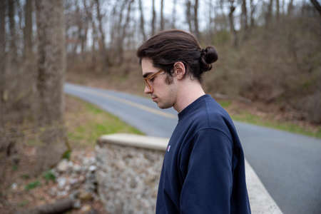 Handsome young caucasian man with downcast eyes, sadness depression loss contemplation concepts all...
