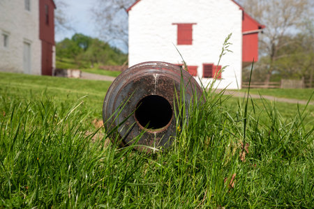 View down the barrel of a colonial cannon in the grass at iron forgeの写真素材