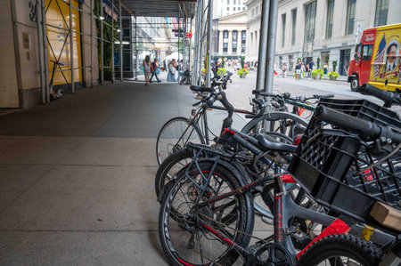 Busy NYC street scene with row of bikes under scaffolding pedestrians