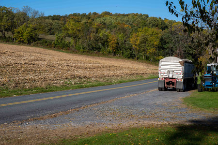 Farm truck and tractor stopped on country road rural landscape