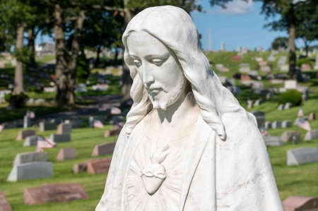White stone cemetery statue of a serene Jesus with sacred heart. Head and shoulders closeup with no people and copy space.の写真素材