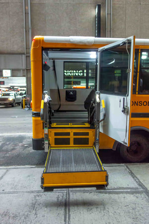 View of lowered wheelchair lift on public school bus city street