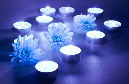 Blue flower and tea candles, spa background