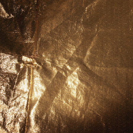 detailed texture of golden fabric in the dark.の写真素材