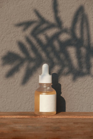 Vitamin C Serum Dropper matt glass Bottle Mock-Up with a leaf shadow. Body treatment and spa. Natural beauty products. Eco cream, serum, skin care yellow serum blank bottle.の写真素材