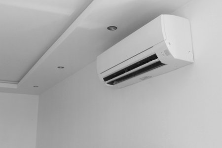 White air conditioning on the white wall in the apartmentの写真素材