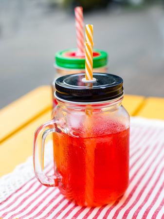 Summer homemade red currant lemonade in a mason jar on ligth wooden table. Close up.の写真素材