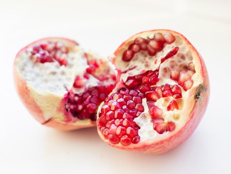 Big Ripe Red Granet or Garnet. Fruits of Red Ripe Pomegranate on the White Background. Vegetarian Concept, Organic Vitamins, Detox, Diet. Organic and Benefit Garnet Fruit. Open Garnet.の写真素材