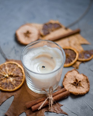 Close up of candle in colorful autumn leaves ana cinnamonの写真素材