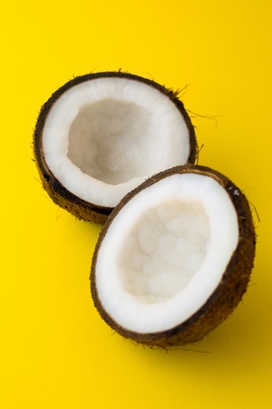 Coconut on yellow colored background, flat lay, top viewの写真素材