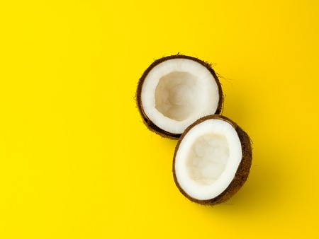 Coconut on yellow colored background, flat lay, top viewの写真素材