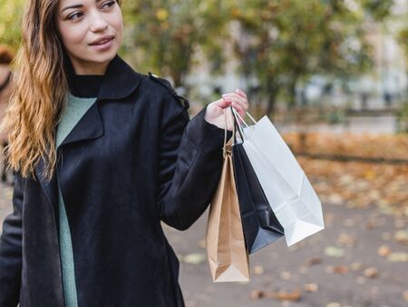 Closeup of woman holding shopping bags on the street. Shopping or sale concept.の写真素材