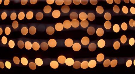 Yellow bokeh balls background. Golden holiday glowing backdrop. Defocused Background With Blinking Starsの写真素材