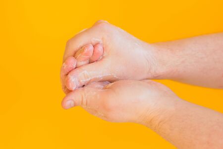 Washing hands isolated on a yellow background. Protection and Hygiene concept. Cleanliness and body...