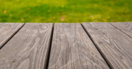 Empty wooden table on bright green abstract blurred summer backgroundの写真素材