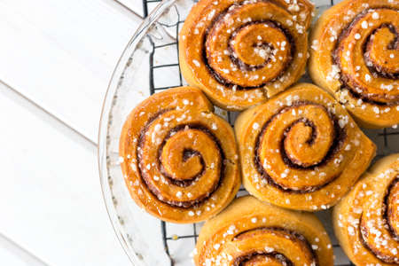 Freshly baked cinnamon buns with spices on a wooden background. Kanelbule - swedish dessert.の写真素材