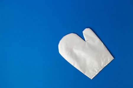 Kitchen silver glove on blue background. Flat lay banner, top view, copy space, heat protection and safety.の写真素材