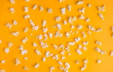 Tasty popcorn pattern on yellow background. Flat lay banner, top view. Cinema and entertainment concept.の写真素材