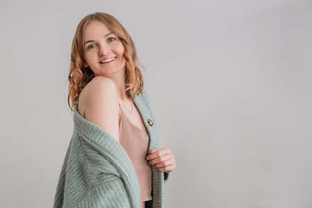 Image of happy young woman posing isolated over grey wall background. Beautiful female looks at camera having her blonde hair. Face expression, feelings and attitudeの写真素材