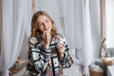 Woman Taking Medicine. Beautiful blond girl taking Medication, Holding Bottle With Pills In Hand. Diet. Nutrition. Healthy Eating, Lifestyle. Headacheの写真素材
